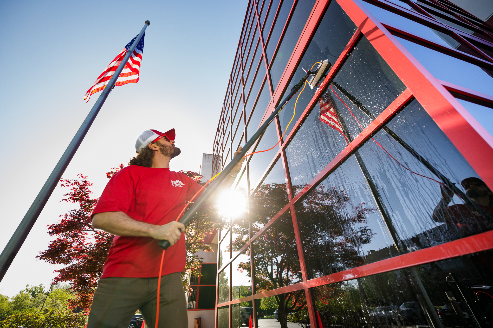 Image of Window Cleaner Using Water-Fed Pole to Clean Commercial Building Windows